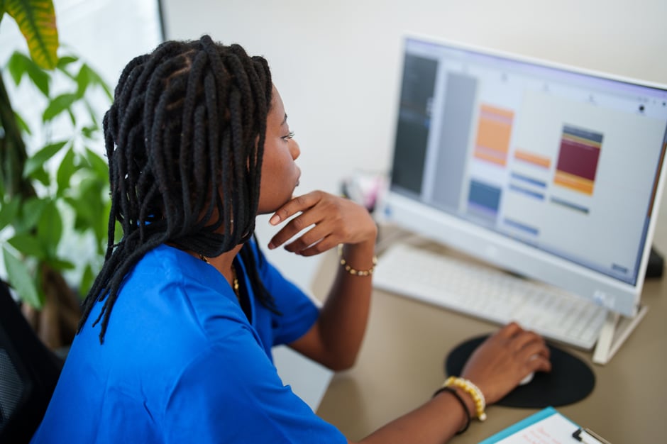 Ophthalmology staff reviewing the practice schedule on a desktop computer, planning appointments.