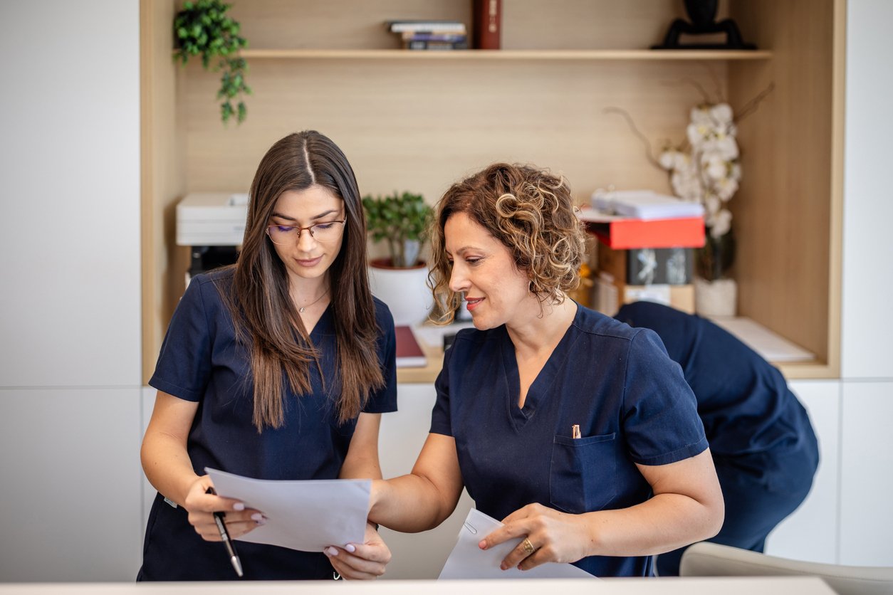 Front desk staff in an ophthalmology clinic reviewing documents.