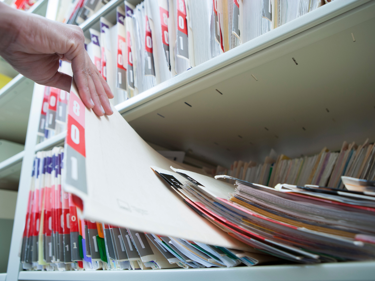 Stack of medical files representing eye care compliance