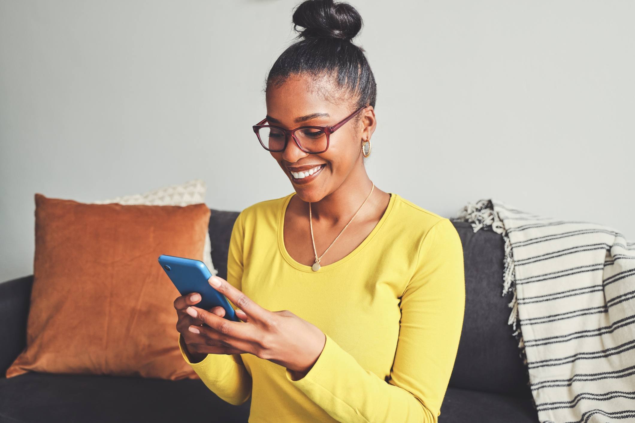 Eye care patient using a smartphone to manage appointment communication from home.