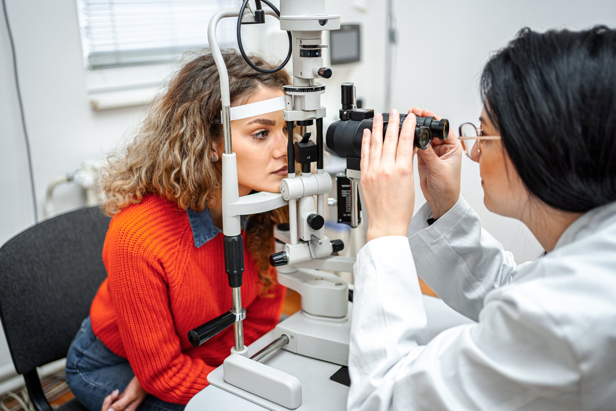 Optometrist performing an eye exam on a patient during a routine visit.