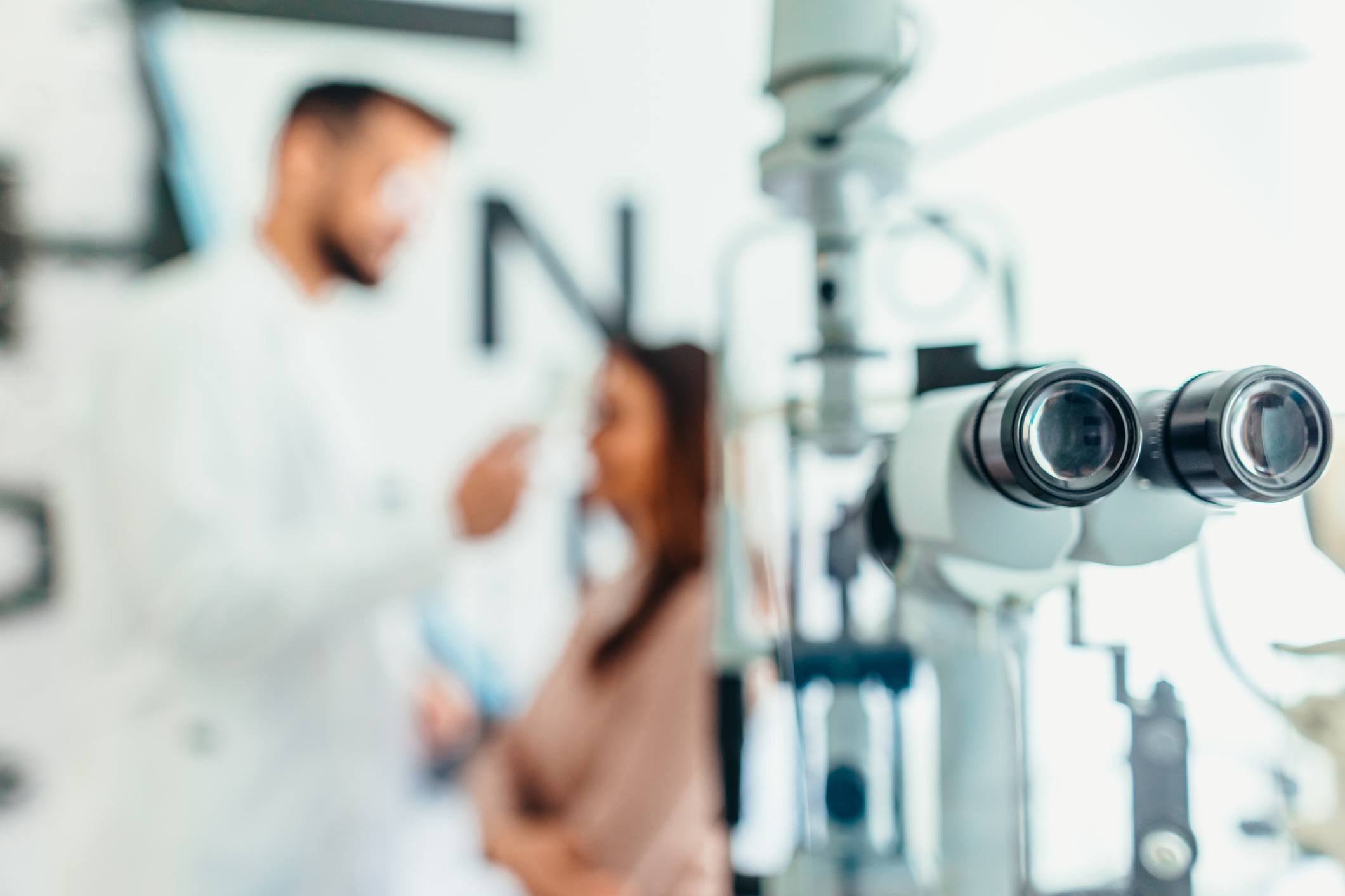 Ophthalmology exam in progress with equipment and patient in background
