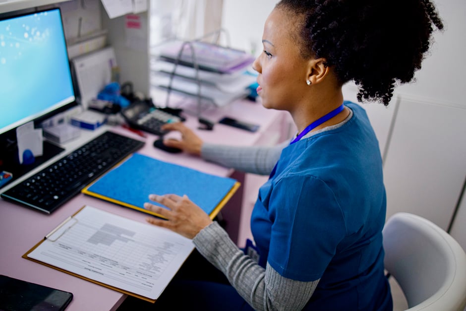 Ophthalmology staff member working on her computer at the front desk. 
