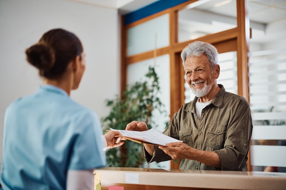 Patient happily handing over forms at the front desk of an optometry practice, part of a seamless patient engagement experience.
