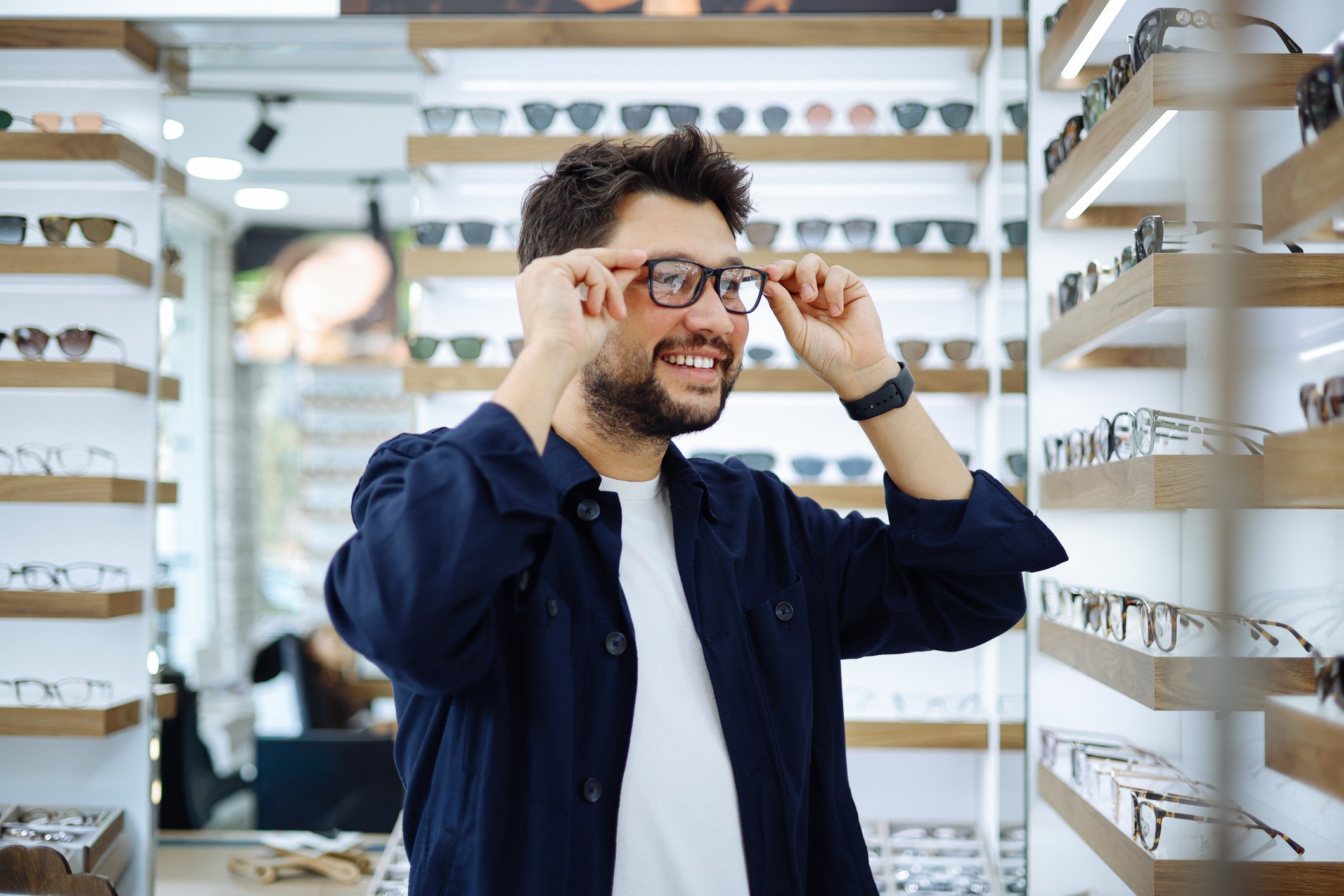 Patient trying on eyeglasses in optical display area.