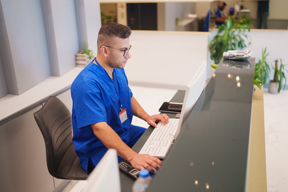Optometry or ophthalmology front desk staff entering patient information into practice management software.